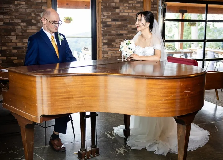 groom serenading bride on the piano